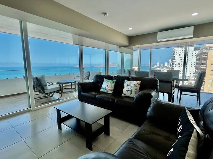Sala y ventanales de Cristal Bay 1301 con vista al mar
